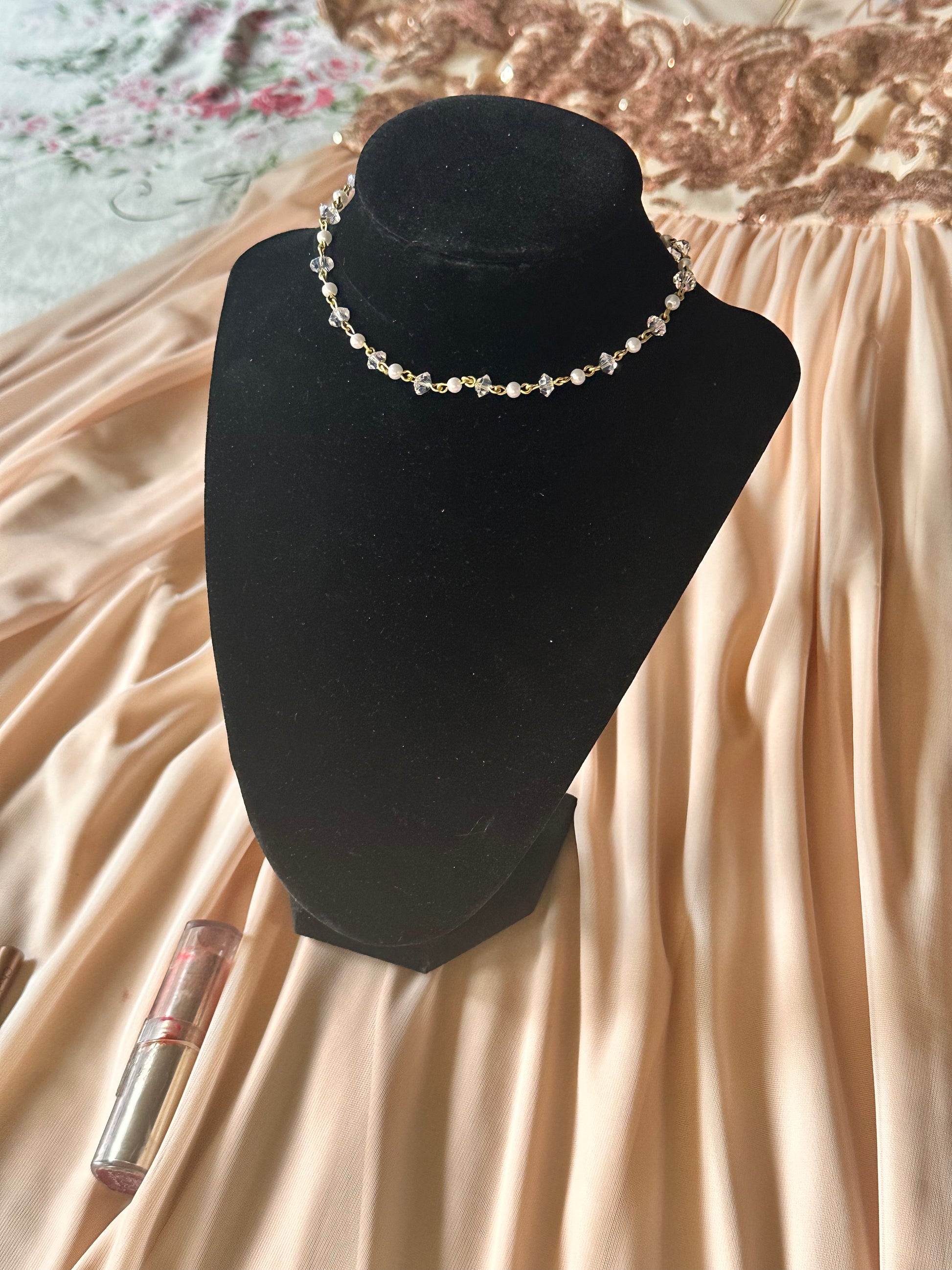 Faux Pearl Choker Necklace laid out on a luxurious satin background, emphasizing its delicate faux pearls and golden wire design.