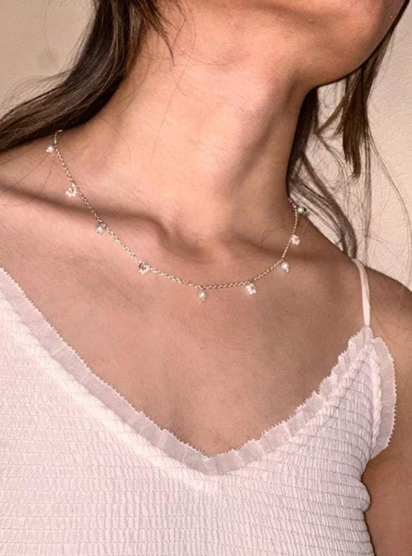 Teatime Necklace with dainty silver chain and pearls, worn by a model for a delicate and elegant look.