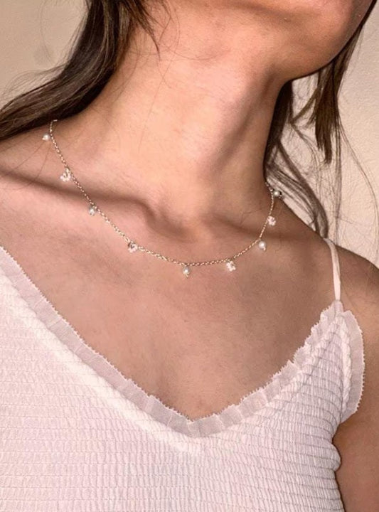 Teatime Necklace with dainty silver chain and pearls, worn by a model for a delicate and elegant look.